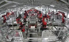 Роботи на поточна линия в автомобилен завод на Tesla в САЩ