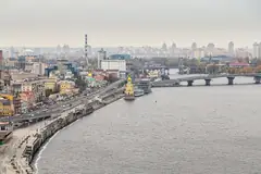 Панорама на Киев с река Днепър, крайбрежна улица, малка църква с жълти куполи на вода и мост